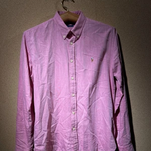 Rosa skjorta från Ralph Lauren - Säljer en oanvänd rosa skjorta från Ralph Lauren i slim fit jag fått som gåva. Skjortan är långärmad och har klassiska knappar framtill. Perfekt för både vardag och fest! 
