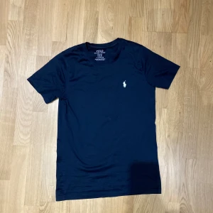 Polo Ralph Lauren T-shirt - Säljer min mörkblåa Polo Ralph Lauren T-shirt vid stolek S. Pris kan sänkas vid snabb affär!