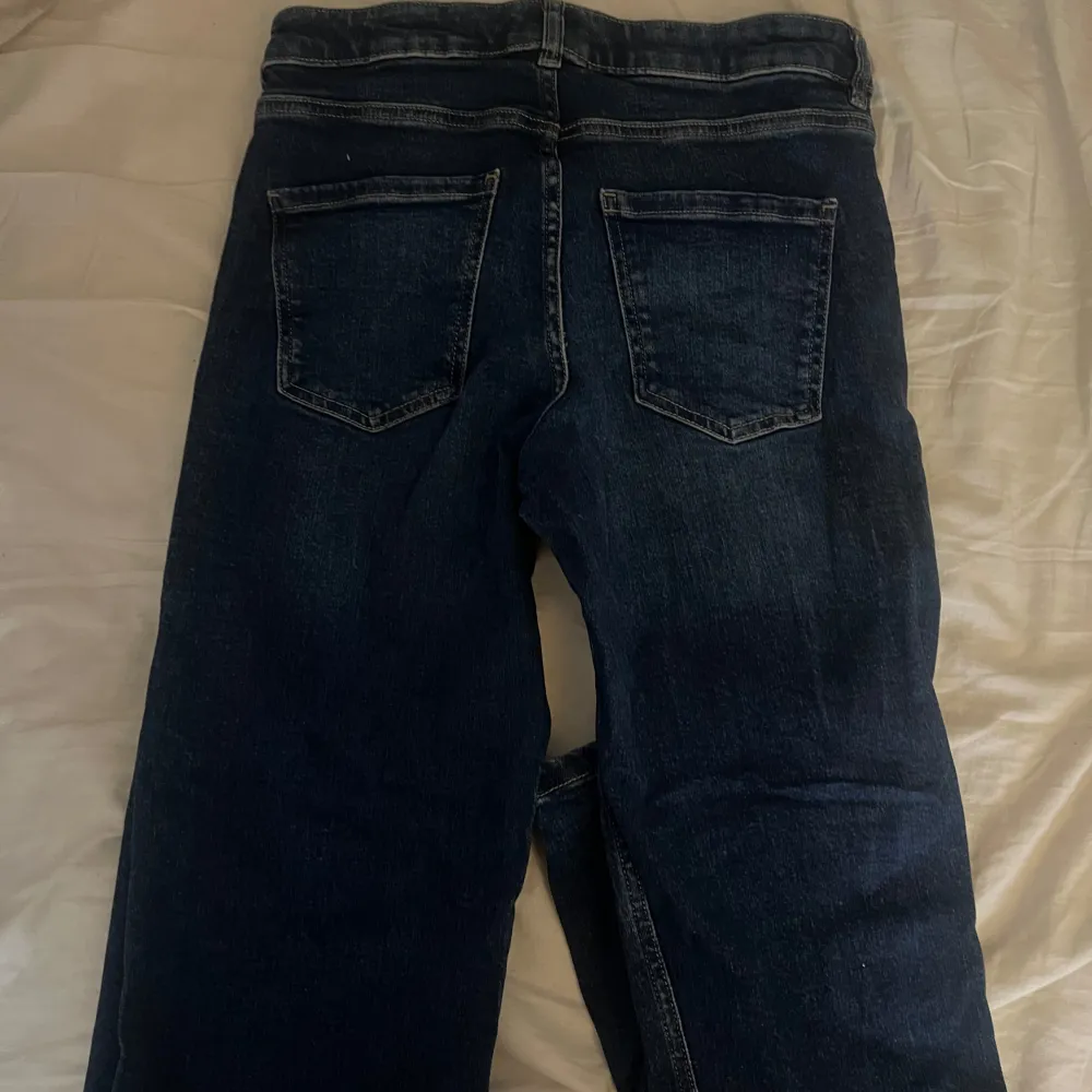 Säljer ett par snygga mörkblå hägmidjade jeans från Kappahl i storlek 40. De har en klassisk femficksdesign och är tillverkade i hållbart denimtyg. Lite liten i strl och väl använda men bra skick.. Jeans & Byxor.