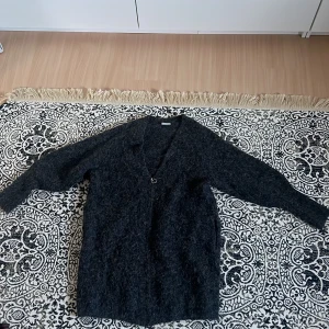 Stickad kofta - Grå stickad kofta från Weekday, sen har smalare ärmar längre ner som blir lösare, som en ”puff”ärm nästan. Dragkedja så den kan både vara öppen och stängd! Inga tecken på användning, strl S men för mig som vanligtvis har M passar den bra!