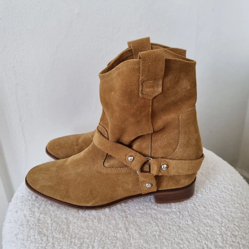 Säljer ett par snygga bruna boots i mocka från H&M. De är i lite cowgirl-stuk och har några enstaka fläckar. De är tyvärr lite för stora för mig men tror de hade varit så snygga till både sommaren och hösten till typ en vit midi-kjol så man lutar lite åt countrystilen!! 🐎. Skor.