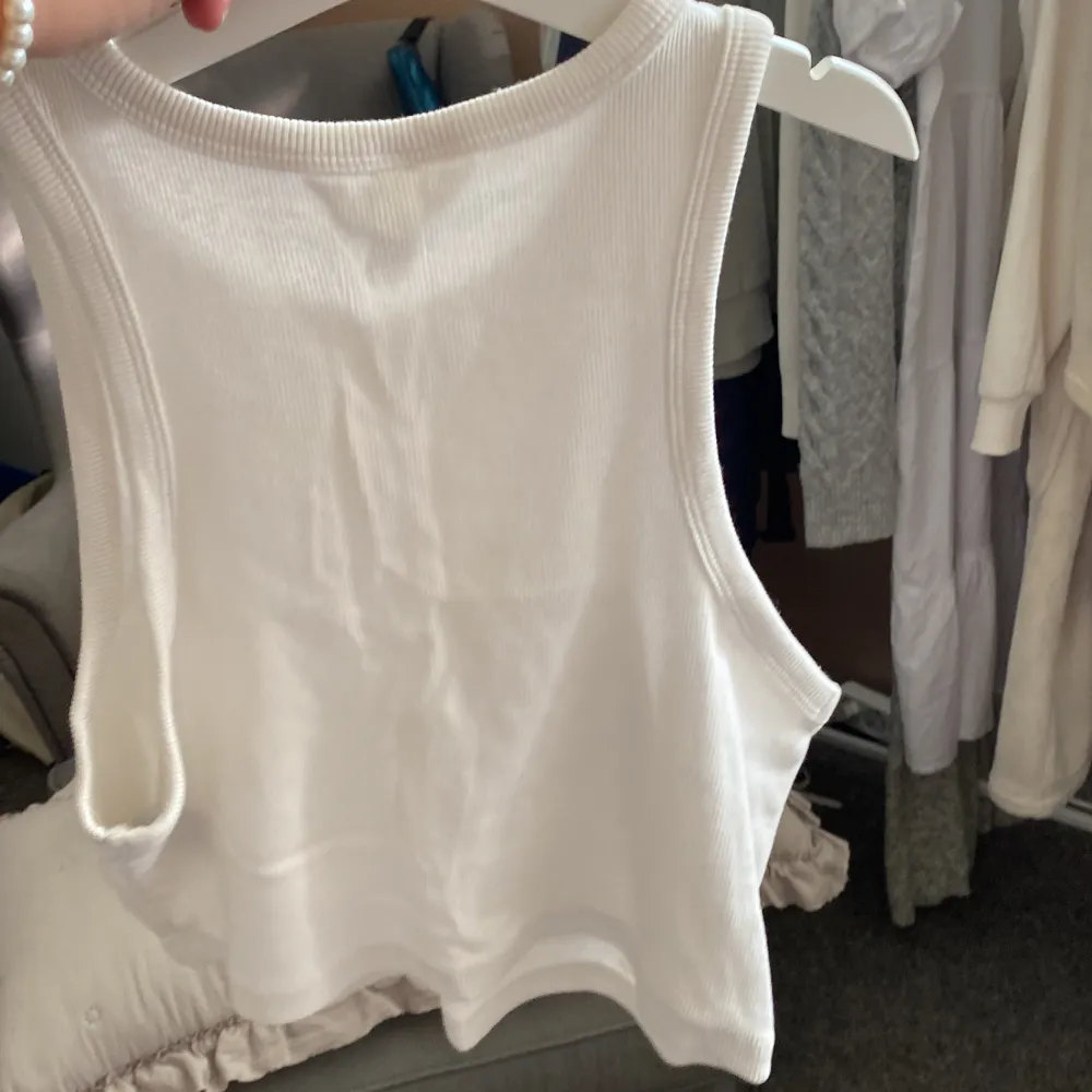 Säljer en vit ribbad linnetopp från H&M. Den är ärmlös och perfekt för sommaren. Toppen är i storlek M och är gjord av ett mjukt och bekvämt material. Perfekt för en avslappnad och stilren look! köparen betalar för frakt . Yläosat.