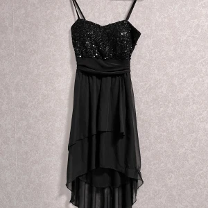 Svart paljettklänning - Säljer en superfin svarta klänning med paljetter upptill och en flytande kort till lång kjol. Perfekt för fest eller nyår! 🖤✨