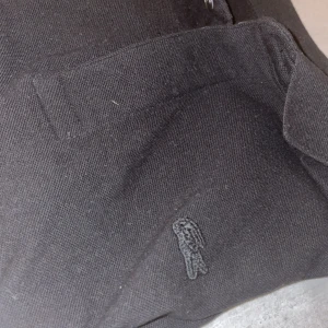 Lacoste Piké  - Svart färgad pike med svart logo. Populär märke som finns få av och väldigt eftersökt. Kontakta vid fler frågor. Pris är inte satt på sten.