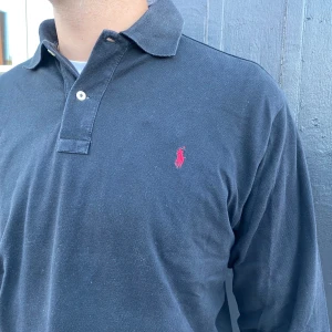 Ralph lauren tröja svart  - Hej! Säljer denna snygga Ralph lauren tröja, tröjan är i gott skick förutom att färgen håller på att lossna uppe vid knapparna men annars inget stort fel. Pris kan diskuteras vid snabb affär! Hör av er om ni har några ytterligare frågor!
