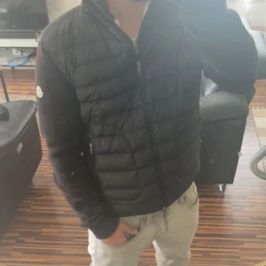 Moncler Cardigan - INTRESSEKOLL på min äkta moncler Cardigan. Kom med ditt bästa bud. Jackan är hel svart och har en liten defekt på armen men inget som syns! Storlek S och passar perfekt för dig som är runt 165-175! Säljer jackan för söker en vinterjacka!