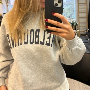 Grå sweatshirt med tryck - Säljer en grå sweatshirt med texten 'MELBOURNE' i mörkblått. 😁💫💫
