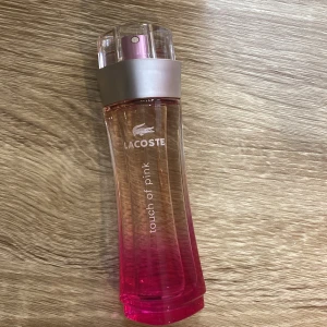 Lacoste Touch of Pink parfym - Säljer en Lacoste Touch of Pink parfym i en snygg flaska som skiftar från rosa till transparent. Perfekt för dig som älskar fräscha och ungdomliga dofter. Flaskan har en modern design med en silverfärgad spraytopp. Passar både till vardags och fest! Använd några gånger så nästan ny!😍🌸 Det var 50ml från början så det är ca 40ml kvar! Nypris: 675kr