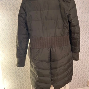Grön dunjacka med textdetalj - Säljer en grön jacka  med cool textdetalj på ärmenLovely från Fornarina . Jackan har långa ärmar och en ribbad midja för extra stil. Perfekt för kalla dagar med sin varma och bekväma passform. Dragkedja framtill och fickor på sidorna. Passar perfekt för höst och vinter! Säljer pga passar inte längre 😩