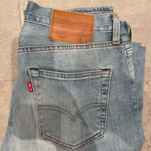 Levi's 501 jeans i ljusblå denim - Säljer ett par klassiska Levi's 501 jeans i ljusblå denim. De har en snygg vintage-look med en rak passform och knappgylf.  Storleken är 28/32.  Skirv vid fubdeingar.