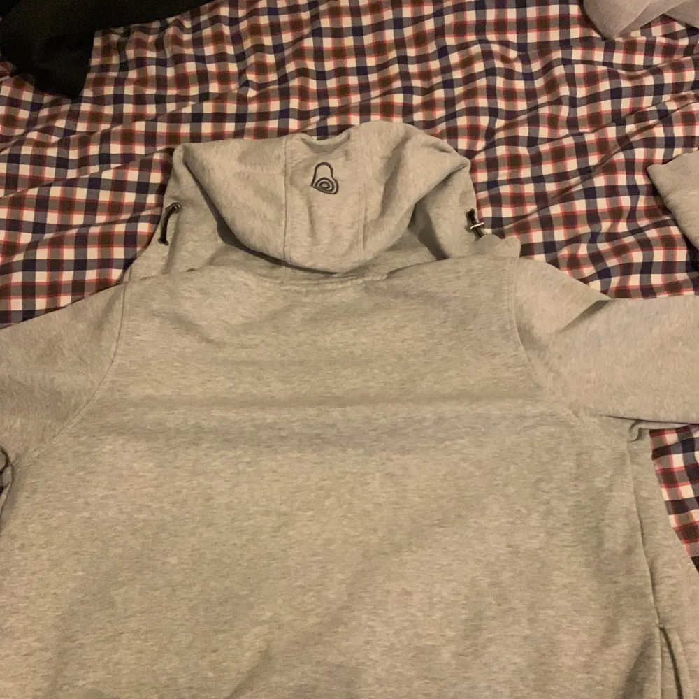 Säljer en grå hoodie från Sail racing  i bra skick. Den har en dragkedja framtill och en praktisk huva. Perfekt för höst och vår, med en bekväm passform och mjukt material. Perfekt för chill dagar eller en promenad i parken.. Jackor.