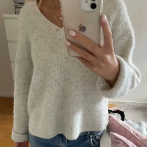 Beige stickad tröja Other stories  - Mysig beige stickad tröja i mycket bra skick. Den har en v-ringad design och långa ärmar, perfekt för höst och vinter. Tröjan är ribbad. Från Other stories🥰