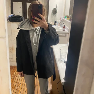 Svart kappa - Säljer en stilren svart kappa i bra skick. Den har en klassisk design med långa ärmar och en normal passform. Perfekt för höst och vår, och funkar både till vardags och fest. Kappan är gjord i ett mjukt material som känns bekvämt att bära.