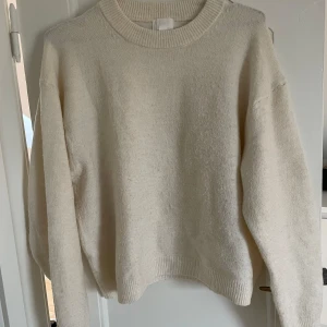 Vit stickad tröja från H&M - Säljer en supermysig vit tröja från H&M i storlek S. Den är perfekt för kyliga dagar med sin mjuka och bekväma passform. Tröjan har långa ärmar och en klassisk rund halsringning. Passar perfekt till både vardag och mysiga hemmakvällar. 🧡