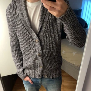 Stickad kofta - Säljer en snygg grå stickad kofta med stora knappar framtill. Perfekt för kyliga dagar, den har en skön passform och är supermysig att ha på sig. Passar både till vardags och lite finare tillfällen. 🧥sjuuukt feeet!!!  Skriv om ni har någon fråga🤙
