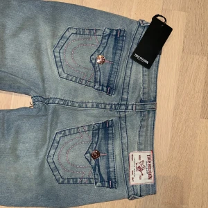 True Religion Bootcut Jeans  -  - Ljusblåa med rosa sömmar - storlek W29, alltså 36/38 - helt nya med lappen på 