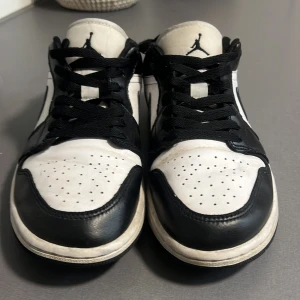 Svartvita Nike Air Jordans - Säljer ett par klassiska svartvita Nike Air Jordans i bra skick. Skorna har en snygg design med svart snörning och det ikoniska Air Jordan-loggan på hälen. Perfekta för både vardag och fest!