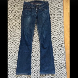 Blå jeans från Tommy Hilfiger - Säljer ett par snygga blå jeans från Tommy Hilfiger i modellen Rhonda CCS. De är i bra skick och har en klassisk bootcut och low waist. Innerbenslängd: 80 cm, midjemått rakt över : 36 cm💞