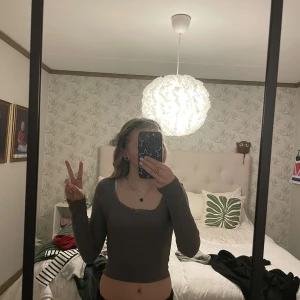 Söt grå topp med lite spets - Grå u formad tröja med lite spets och en söt liten ruset, skönt material med reffligt tyg