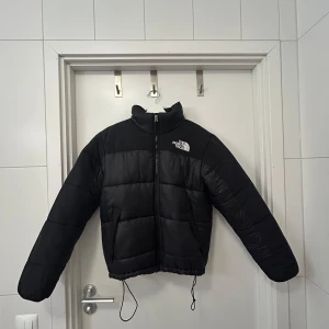 Svart vinterjacka från The North Face - Jättevarm kort vinterjacka från The North Face i large. Liten i storleken, passar mig som vanligtvis bär small/medium. Säljer då den inte kommit till användning och bara använts fåtal gånger. Skick nästan som helt ny🙏🏼🙏🏼  Köpt för 2699kr⭐️  Supervarm och perfekt i det kalla🫶🏼Pris går att förhandlas vid snabb affär!!