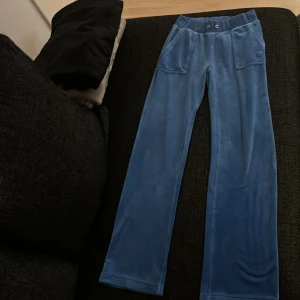 Blå mjukisbyxor från Juicy Couture - Säljer ett par blå mjukisbyxor från Juicy Couture i storlek XS. Byxorna har en bekväm passform och har fickor på baksidan men snöret är tyvärr borta 