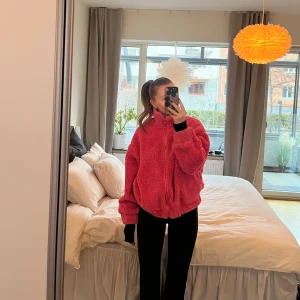 Rosa teddyjacka från Nelly - Mysig rosa teddyjacka från Nelly. Perfekt för kyliga dagar med sin fluffiga och varma design. Jackan har en dragkedja framtill och långa ärmar. En riktig färgklick i garderoben!