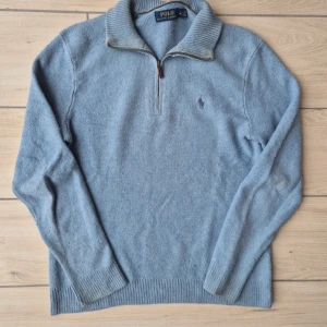 Ljusblå stickad tröja från Ralph Lauren - Säljer en stilren ljusblå stickad tröja från Ralph Lauren med dragkedja vid halsen.