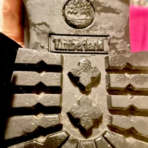 Svarta stövlar från Timberland - Snygga svarta stövlar från Timberland med hög snörning och robust sula. Perfekta för höst och vinter. Tillverkade i mocka och skinn för en stilren look.