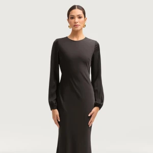 Svart satin klänning - Elegant svart långklänning med långa ärmar. Klänningen har en figurnära passform.. Använd endast vid ett tillfälle och därför nästan helt ny. 