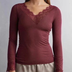 Vinröd långärmad topp med spetsdetaljer - Skirsnygg vinröd tröja från Intimissimi ❤️Köpte i Tyskland för nån månad sen men är knappt använd då jag inte tycker den passar mig 🎀skriv för fler frågor och funderingar💞💞