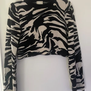 Svart och vit croppad tröja med zebramönster - Säljer en croppad tröja med zebramönster i svart och vit. Tröjan har långa vida ärmar i storlek. I storlek S men sitter bra på de med xs också. Lite nopprig men släpper lätt!