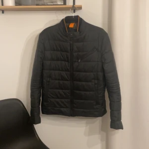 Svart quiltad jacka från Boss - Snygg  jacka från Boss med dragkedja och hög krage. Kan sänka priset vid snabb affär
