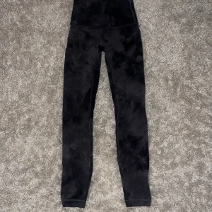  leggings från Lululemon - Snygga svarta leggings från Lululemon med ett diskret mönster. De är högmidjade och har en tight passform, perfekta för träning eller en avslappnad dag. Materialet är mjukt och stretchigt för bästa komfort.