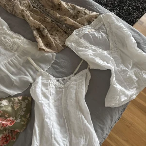 Vit ärmlös topp från Peekaboo Denmark - Säljer en söt vit ärmlös topp från Peekaboo Denmark. Toppen har en vacker spetsdetalj runt den v-ringade halsen och är perfekt för varma dagar. Den är tillverkad i ett lätt och luftigt material.