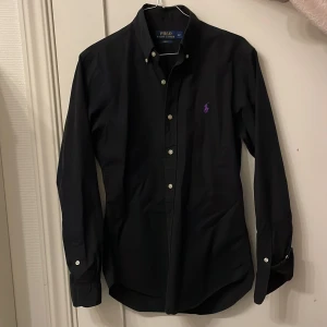 Ralph lauren skjorta  - Ralph Lauren skjorta storlek herr S. Smal passform. Slim fit. Färg svart. Jättefint skick. Bara att höra av dig om du har någon fråga. 