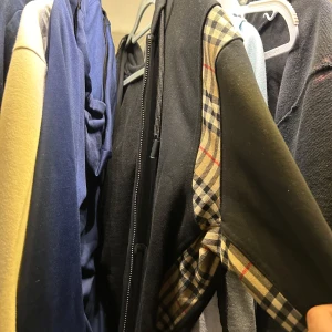 Svart hoodie från burberry  - Säljer en svart hoodie snygga rutiga detaljer på ärmarna. Den har en dragkedja framtill och en bekväm huva. Perfekt för höst och vår när du vill vara både stilren och bekväm. Pris går att diskuteras 