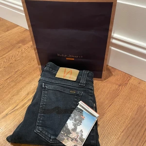 Nudie jeans - Ett par svarta/ väldigt mörkblåa nudie jeans. De har inga hål eller skador, förutom på insidan där några lappar har klippts bort. Ej säker vilken modell, men sitter exakt som skinny lin/ tight terry. Alltså ett par slim fit jeans. W29 L32