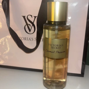 Victoria's Secret Coconut Passion - Säljer en Victoria's Secret Coconut Passion body mist. Den har en tropisk doft av kokosnöt och vanilj, perfekt för att känna sommarvibbar året runt. Flaskan är genomskinlig med en gyllene kork och rymmer 250 ml. Perfekt för stranden eller en dag i solen! 🌴