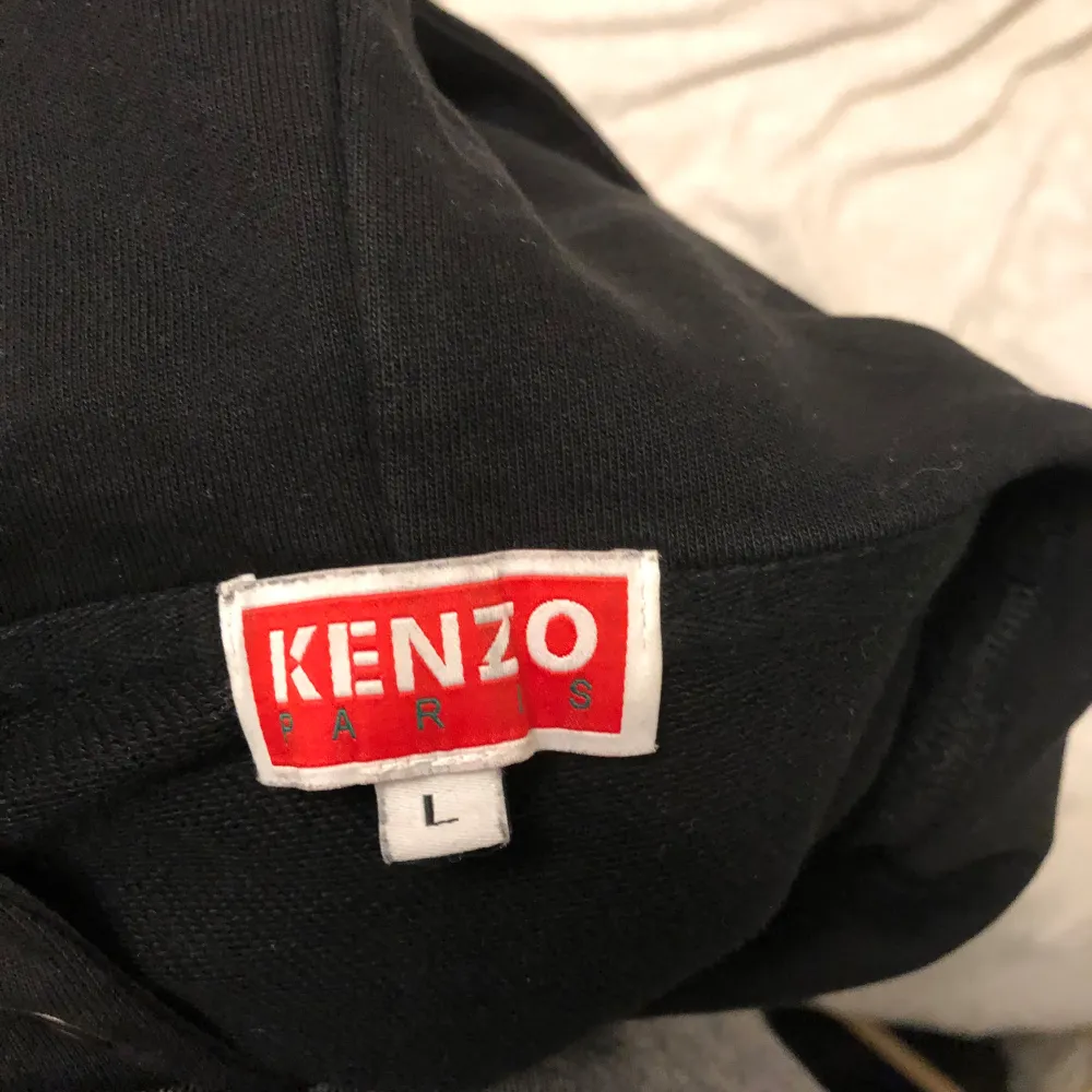 Säljer en svart Kenzo hoodie med ett coolt tigertryck i blått och vitt på framsidan. Den har en klassisk passform med huva och dragsko. Perfekt för en avslappnad stil eller att bära till vardags. 🐯. Tröjor & Koftor.