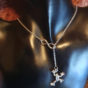 Halsband med evighetstecken & groda - Gulligt halsband med groda & evighetstecken oanvänd. Mått på kedjan är: 44 + 5 cm ✨️Titta igenom alla mina upplagda och köp fler saker i bundle för att spara på frakten och få allt du köpt i ett och samma paket✨️