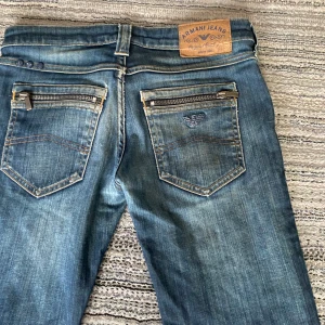 Blå jeans från Armani - Säljer ett par snygga blå jeans från Armani i mycket bra skick. De har en klassisk femficksdesign med dragkedja på bakfickorna.