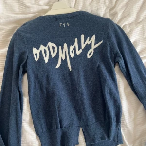 Odd Molly kofta - Supersöt blå kofta med knappar och text på ryggen från Odd Molly. Storlek 1 vilket motsvarar S/36. Använd ytterst fåtal gånger och är i fint skick. 250kr. 
