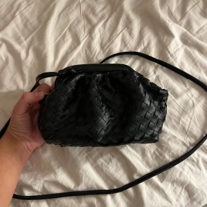 Tråd väska  - Svart söt liten väska med ett band som går att ta av. Går att hålla som clutch eller ha ett långt band över kroppen. Vet inte märke☺️