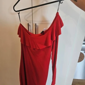 Tajt röd klänning  - Säljer nu en röd tajt klänning med en långarm och andra off shoulder. Sparsamt använd 