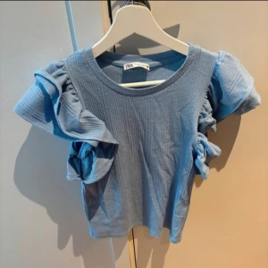 Topp med volanger - Ljusblå topp med volangärmar från Zara.