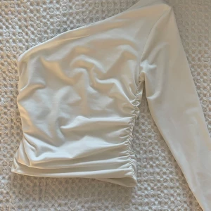 Vit oneshoulder topp - Vit oneshoulder topp i storlek xs från Vero Moda! Inte genomskinlig då de är tjockt tyg. Aldrig använd💞