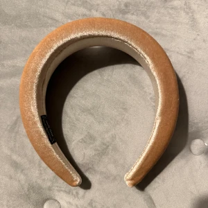 Beige sammet diadem - Säljer ett superchict beige diadem i sammet. Perfekt för att ge din outfit en elegant touch. Det är mjukt och bekvämt att bära hela dagen. Passar både till vardags och fest!