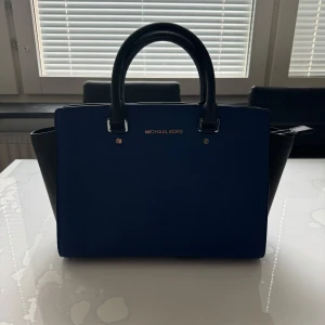 Michael Kors väska - Danväska Knappt använd Äkta Färg: Blå/svart Axelrem följs med.