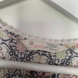 Mönstrad klänning från Odd Molly - Säljer en superfin mönstrad klänning från Odd Molly i storlek Xs. Klänningen har ett vackert blommigt mönster i olika färger som blå, rosa och beige. Den är kortärmad och har en knytning framtill. Perfekt för sommar och vår! 💖