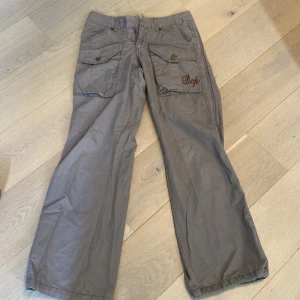 låg midjade cargos - dom är lite slitna längst ner och har ingen knapp för att knäppa byxorna men de har en dragkejda
